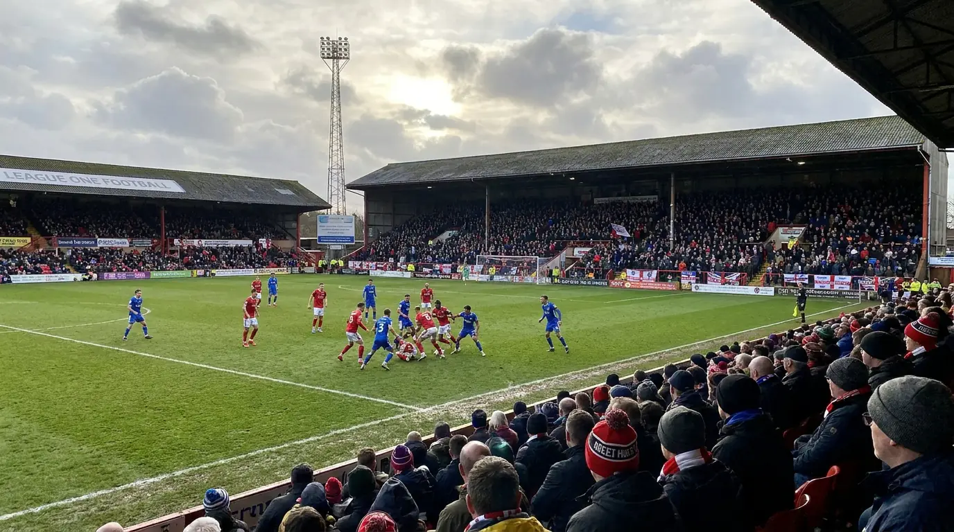 League One football match in progress at a compact English ground with fans in the stands