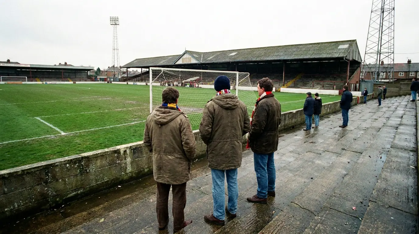 Small group of away fans on a terrace at a League Two ground