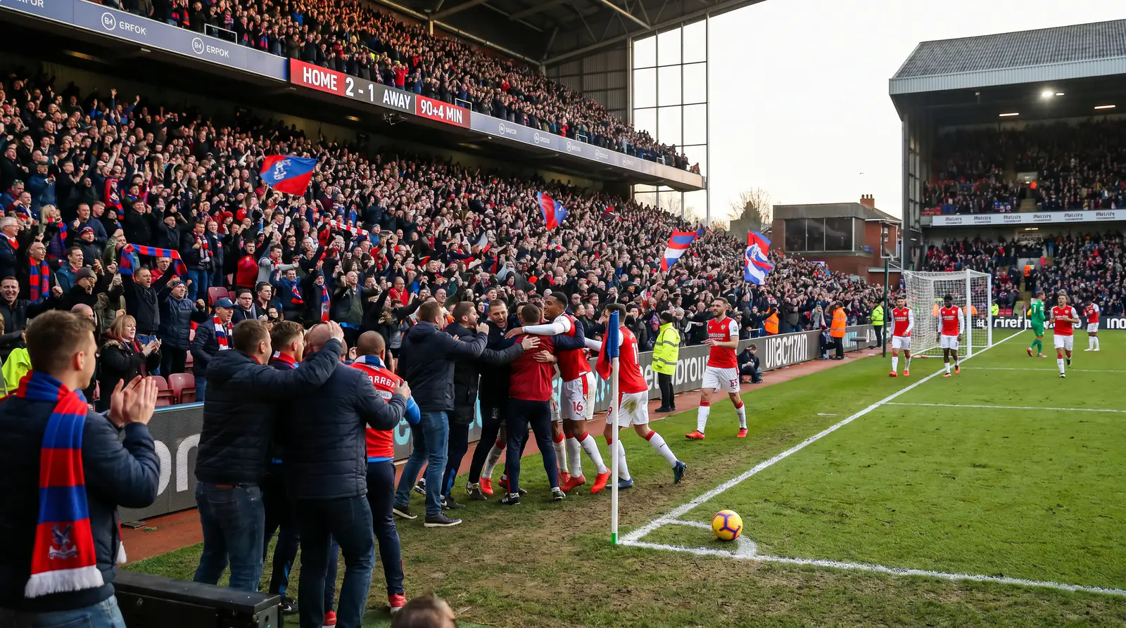 Football fans celebrating at a crucial late-season Premier League match
